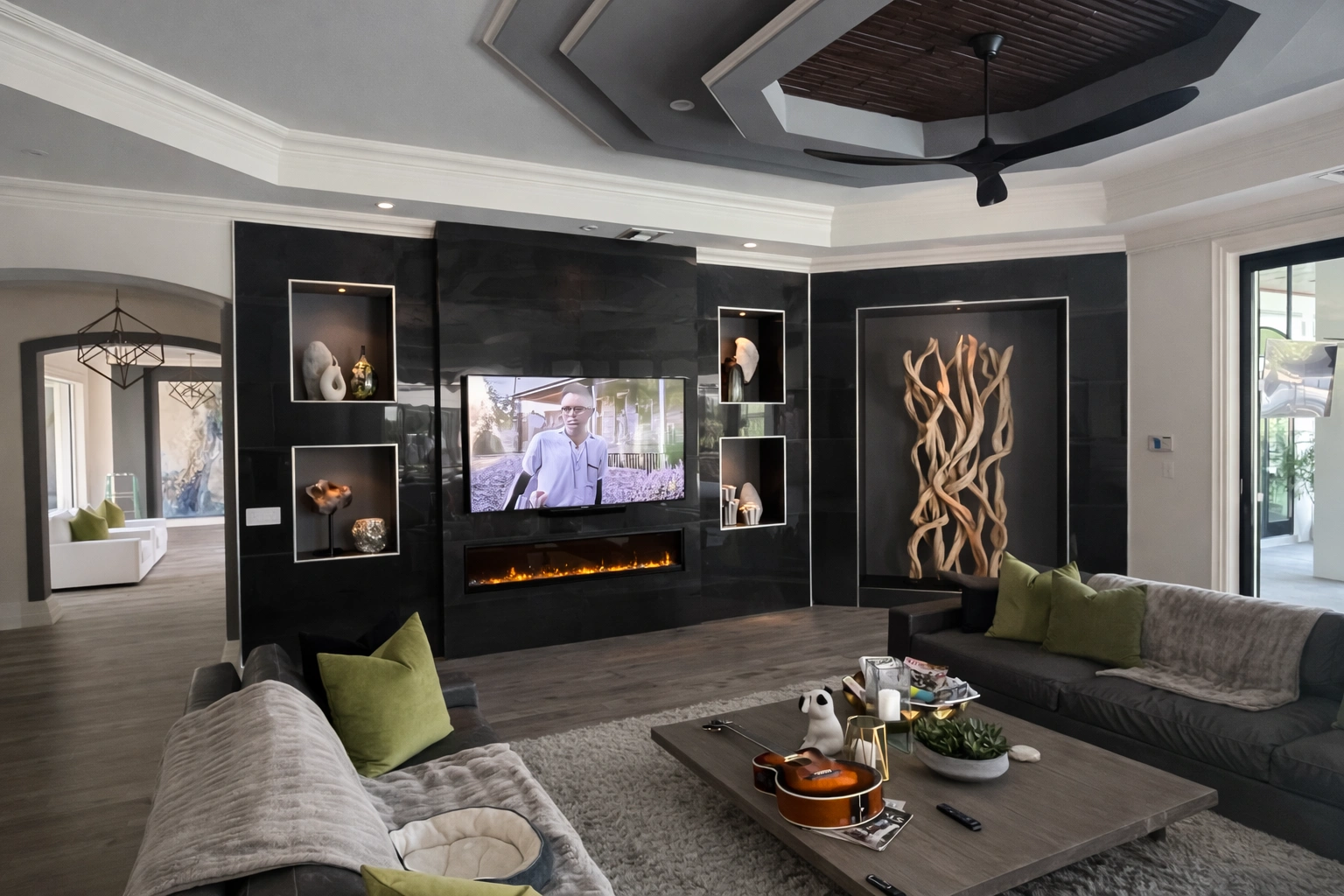Bold dark media wall — gloss black built-ins, fireplace, dramatic coffered ceiling